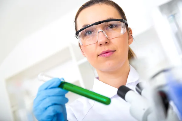 Mulher química testando amostra de líquido em laboratório — Fotografia de Stock