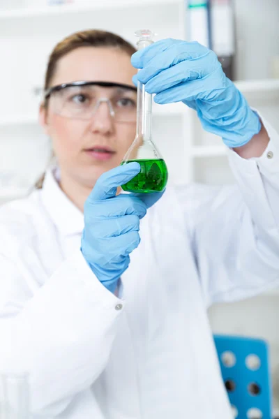 Mulher química testando amostra de líquido em laboratório — Fotografia de Stock