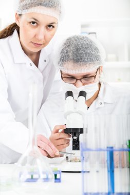 Kadın bilim adamı bir laboratuarda mikroskop ile çalışma