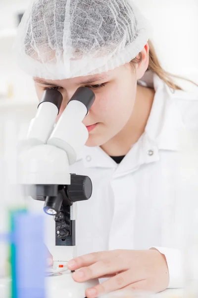 Woman scientist working with a microscope in a lab — Stock Photo, Image