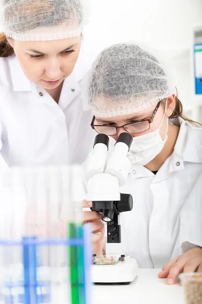 Femme scientifique travaillant au microscope dans un laboratoire — Photo