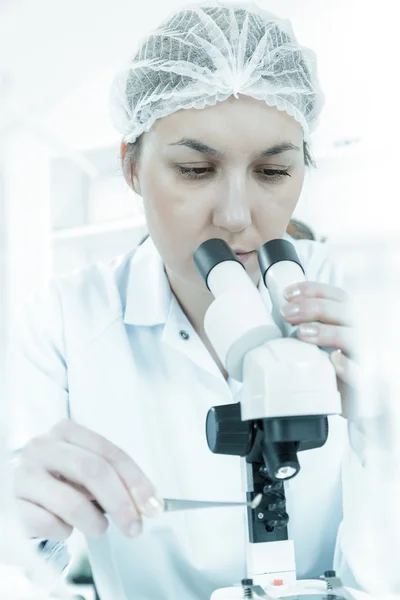 Mujer científica trabajando con un microscopio en un laboratorio — Foto de Stock