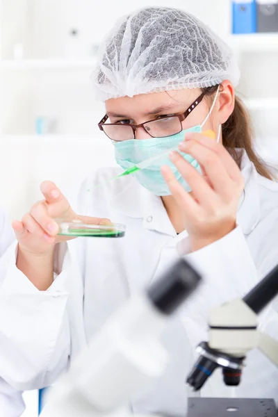 Vrouwelijke onderzoeker met glazen apparatuur in de lab - zachte focus op glas en handen. — Stockfoto