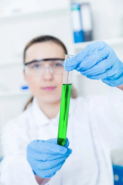 Pesquisador fêmea com equipamento de vidro no laboratório foco suave em vidro e mãos . — Fotografia de Stock