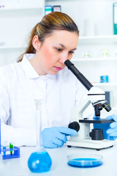 Vrouw die met een microscoop in een lab werkt — Stockfoto