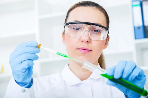 Vrouwelijke onderzoeker met glazen apparatuur in het lab. — Stockfoto