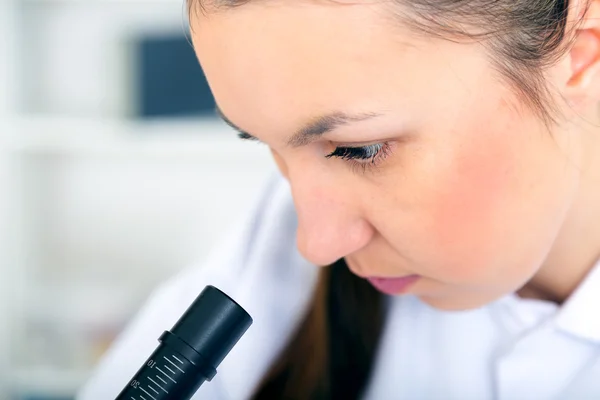 Kvinna som arbetar med ett Mikroskop i ett labb — Stockfoto