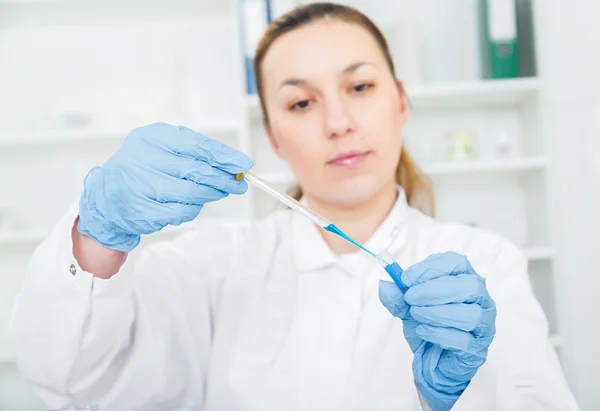 Vrouwelijke onderzoeker met glazen apparatuur in de lab - zachte focus op glas en handen. — Stockfoto