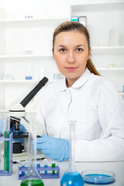 Femme travaillant avec un microscope dans un laboratoire — Photo