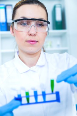 kadın araştırmacı laboratuarda cam ekipman ile.