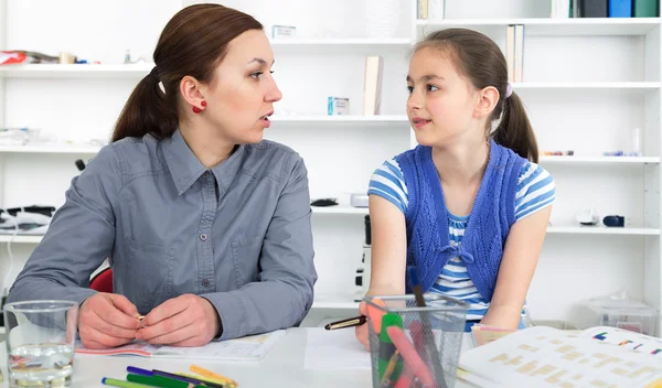 Moeder helpen dochter met huiswerk. — Stockfoto