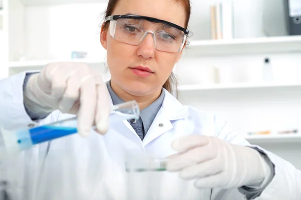 Vrouwelijke onderzoeker met glazen apparatuur in het lab. — Stockfoto