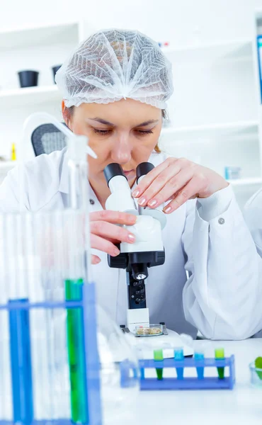 Woman working with a microscope in a lab — Stock Photo, Image