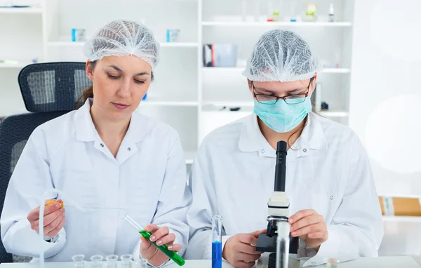 Team av forskare i ett laboratorium som arbetar på kemiska tester — Stockfoto
