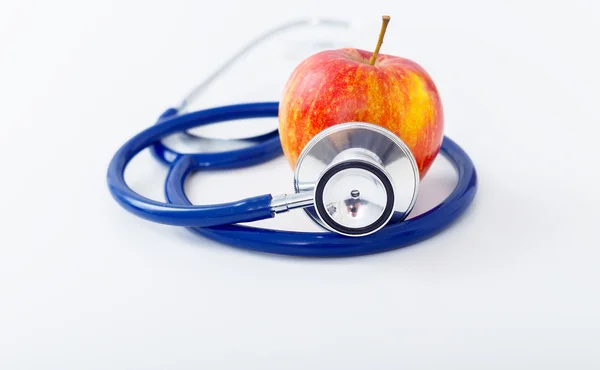 Rött äpple med stetoskop på vit bakgrund — Stockfoto