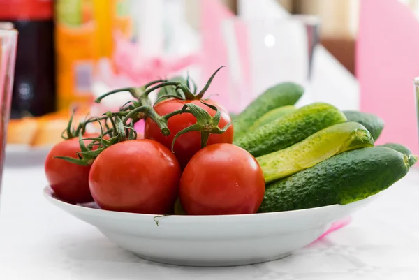 Pepinos verdes em conserva e tomate fresco na tigela na mesa — Fotografia de Stock