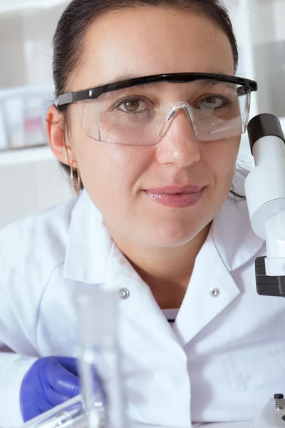 Mujer trabajando con un microscopio en un laboratorio — Foto de Stock