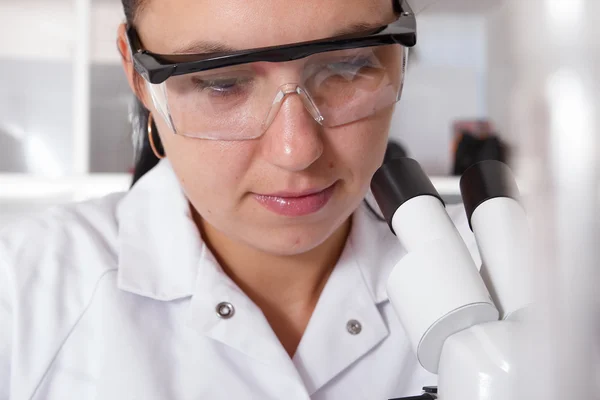 Mulher trabalhando com um microscópio em um laboratório — Fotografia de Stock