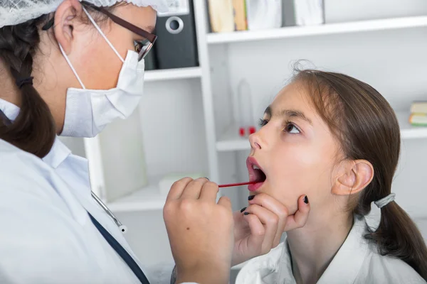 Médico comprobar garganta de niña.. imagen tonificada . — Foto de Stock