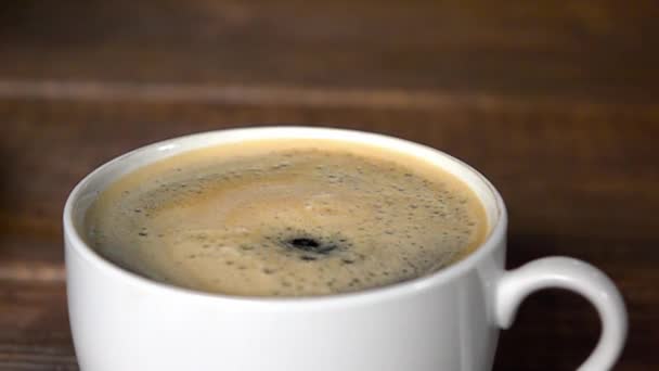 Goutte de café faisant onduler dans la tasse.. Mouvement lent 