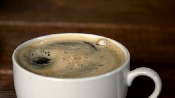 Goutte de café faisant onduler dans la tasse.. Mouvement lent 