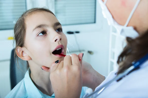 Doctor check throat of little girl..toned image. — Stock Photo, Image