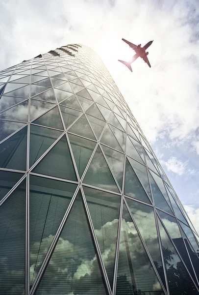 Avião sobre torre de escritório — Fotografia de Stock