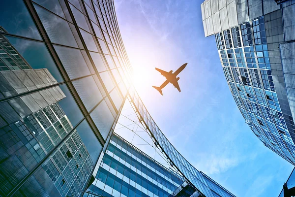 Plane over office towers — Stock Photo, Image