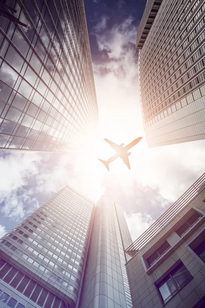 Samolot leciał nad nowoczesne biura drapacze chmur — Zdjęcie stockowe