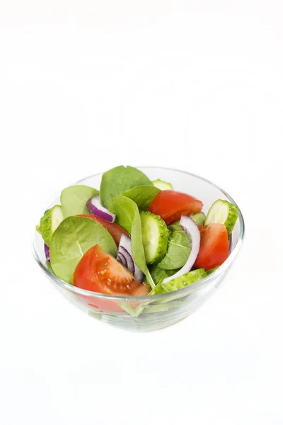 Kleurrijke salade in de glazen kom op een witte achtergrond — Stockfoto
