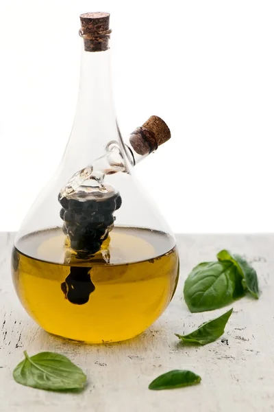 Cruette en verre avec huile d'olive et feuilles de basilic — Photo