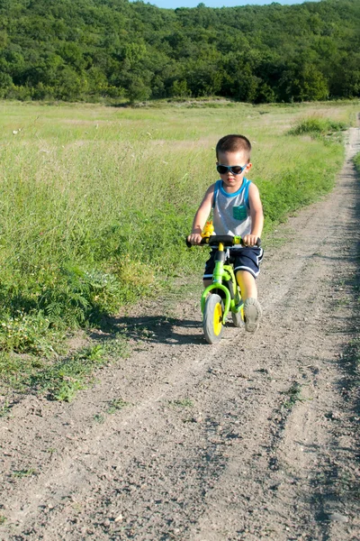 Babyjongen rijden op zijn eerste fiets zonder pedalen — Stockfoto