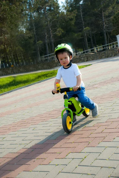 Babyjongen rijden op zijn eerste fiets. Fiets zonder pedalen. — Stockfoto