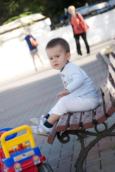 Bébé garçon assis sur banc — Photo