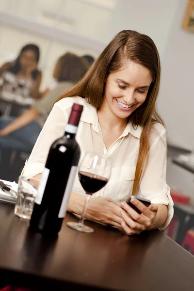 Junge Frau checkt ihr Smartphone — Stockfoto