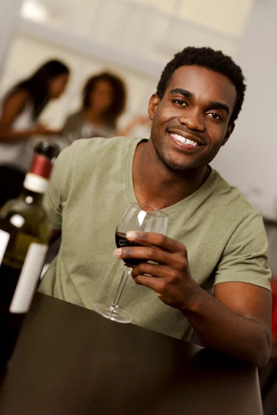 African-American man holiding a wine glass in a restaurant — Stock Photo, Image