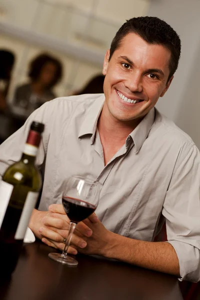 Junger Mann mit einem Glas Wein in einem Restaurant — Stockfoto