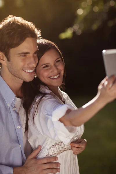 Jovem casal tomando uma selfie no parque — Fotografia de Stock