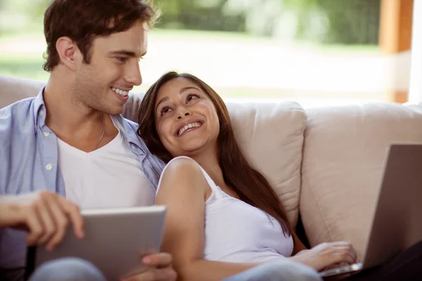Молода пара розслабляється з ноутбуком і планшетом вдома — стокове фото