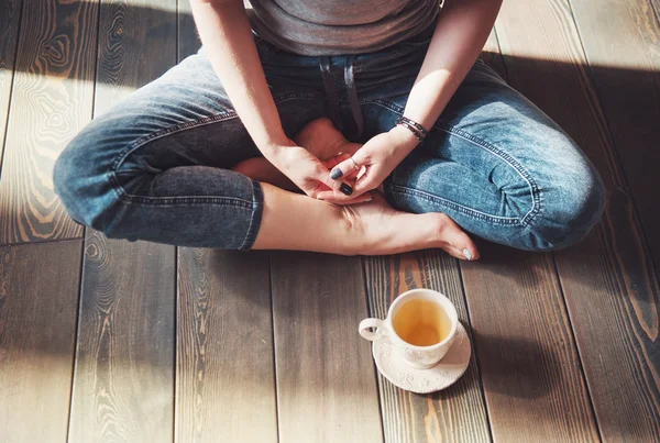 Accogliente foto di giovane donna con una tazza di tè seduta sul pavimento — Foto Stock