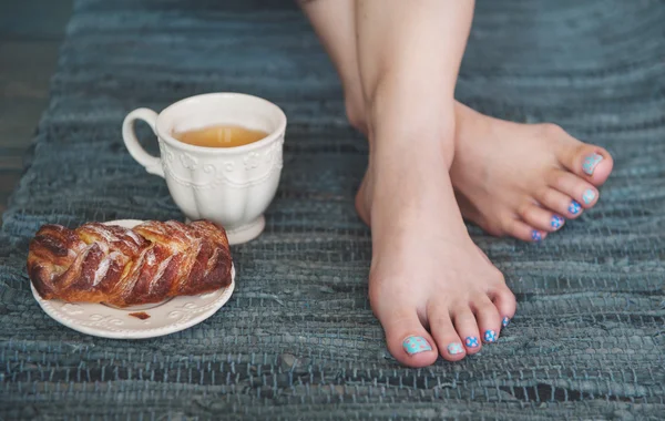 Acogedora foto de pies de mujer con té y pastel — Foto de Stock