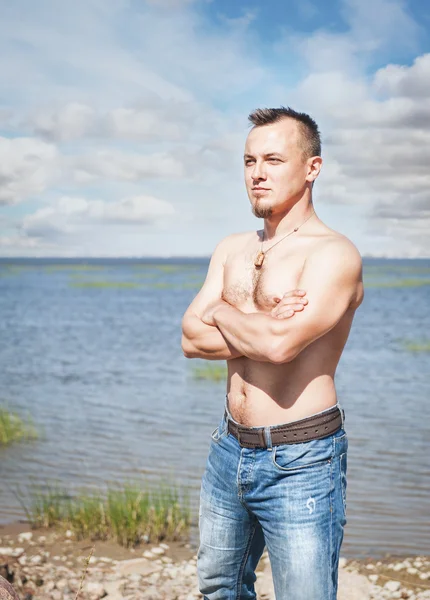 Knappe man met naakte torso staan in de zee — Stockfoto