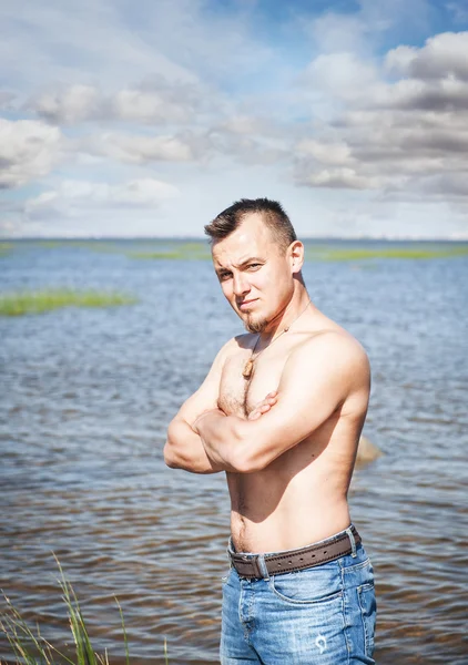 Όμορφος άντρας με γυμνό τον κορμό όρθια στη θάλασσα — Φωτογραφία Αρχείου