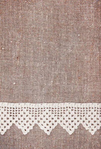 Vintage background with lace on the old burlap — Stock Photo, Image