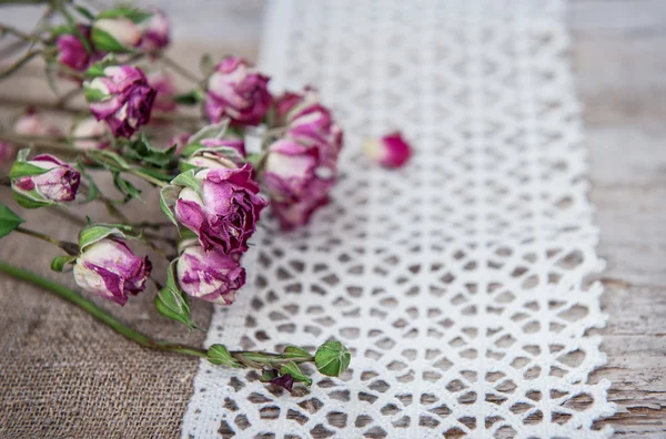 Vintage background with dry tea roses on lace and burlap — Stock Photo, Image