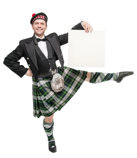 Young man in clothing for Scottish dance with empty banner — Stock Photo, Image