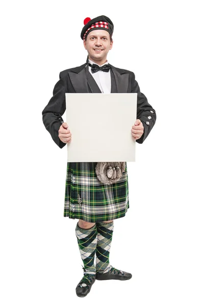 Scottish man in traditional national costume with empty banner — Stock Photo, Image