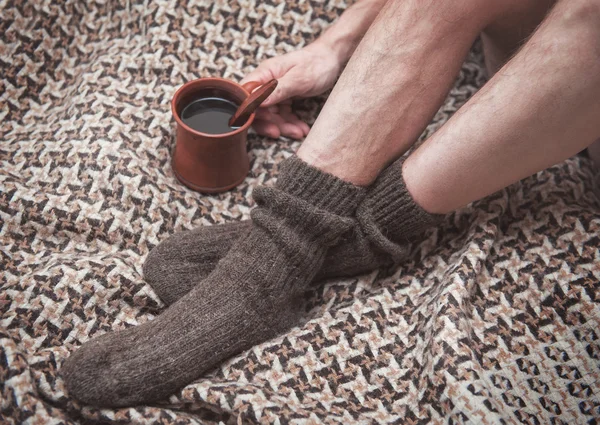 男子脚上羊毛格子和杯咖啡 — 图库照片