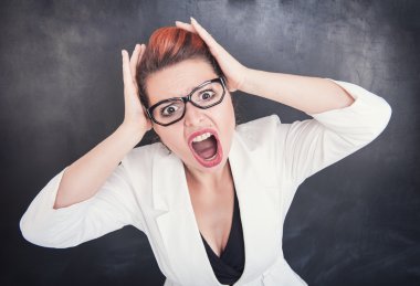 Angry screaming teacher on blackboard background clipart