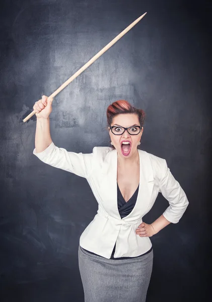 Angry screaming teacher with pointer on blackboard background — Stock Photo, Image